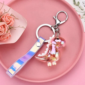Detail of cute dinosaur keychain with silver hardware and iridescent laser wrist strap