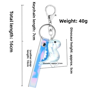 Detail view of iridescent dinosaur keychain with a blue gradient wrist strap and silver clasp