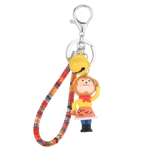 Cartoon Monkey King keychain with yellow bell and colorful braided strap on white background