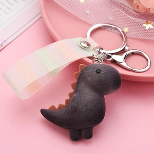 Detailed view of flocked purple dinosaur keychain with a striped ribbon and silver lobster clasp