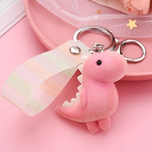 Close-up of pink flocked dinosaur keychain with matching striped strap and lace background