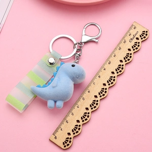 Detail of blue flocked dinosaur keychain with striped strap and silver metal lobster clasp