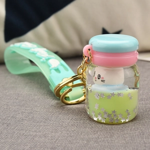 Detail of mint green liquid keychain with star sequins and cute animal figure