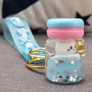 Macro shot of liquid acrylic keychain with cute white rabbit and blue stars inside