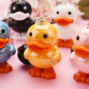 Close-up of cute acrylic duck keychains in five colors with glossy finish and metal ring