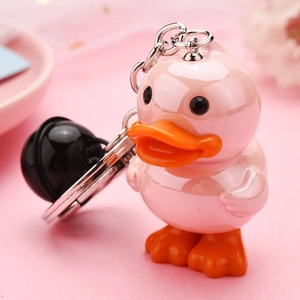Close-up of pink acrylic duck keychain with silver chain and a glossy black bell charm