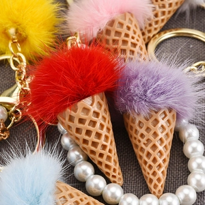Macro view of colorful plush ice cream keychains with golden metal rings and pearl decor