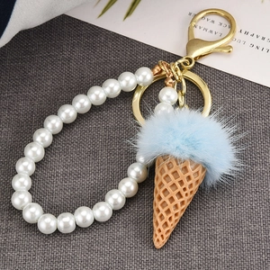 Cute ice cream keychain with blue faux fur ball, white pearls, and gold metal hardware