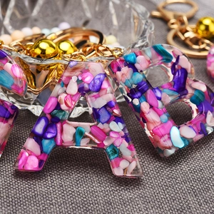 Resin alphabet keychain letter A with colorful stone inlay and gold bell accessory