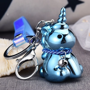 Macro view of blue electroplated unicorn keychain with braided rope and silver bell