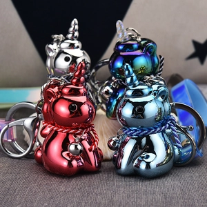 Detail of metallic unicorn keychains with bells and woven straps in multiple colors