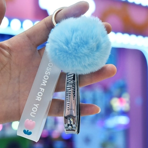 Close-up of zebra pattern nail clipper with blue pompom and silicone wrist strap