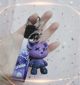Macro detail of purple galaxy gradient bear keychain with metallic clip and fashion strap