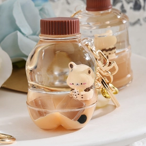 Brown milk tea cup keychain with cute bear, flowing liquid, and golden metal ring