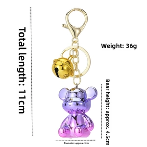 Detail view of colorful gradient bear keychain with golden bell and metal clip hooks