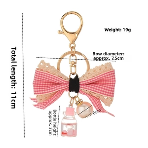 Detail of pink plaid bow keychain with liquid mini bottle and pearl pendant 11cm