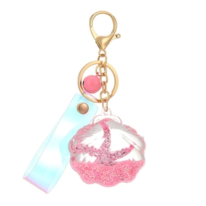 Pink liquid sand shell keychain with laser strap and bell on a white background