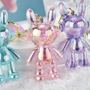 Three colorful acrylic bunny keychains in iridescent blue pink and purple with gold rings