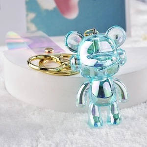 Detailed macro view of an iridescent blue mechanical bear keychain on a white pedestal