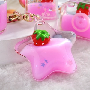 Detail of pink strawberry liquid quicksand keychain in star shape with golden metal clasp