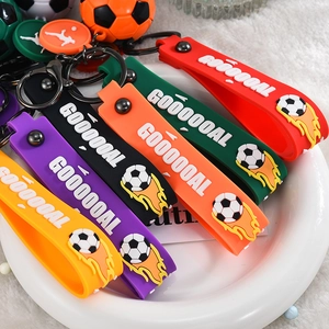 Dettaglio di portachiavi da calcio in silicone colorato con grafiche GOOOAL in un piatto