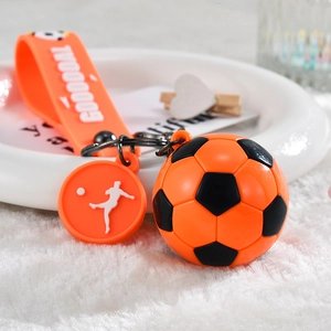 Dettaglio ravvicinato di un portachiavi da calcio arancione con pallone in PVC e cinturino
