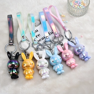 Set of six colorful iridescent bunny keychains with matching laser PVC straps on white tray