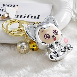 Detail of silver electroplated fox keychain with yellow bell and clear glitter bead