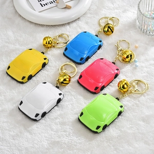 Sports car-shaped keychain charm set with colorful plastic shells and golden bells