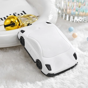 White sports car keychain with golden bell and ring on soft white plush background