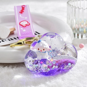 Macro detail of cloud-shaped liquid quicksand keychain with purple glitter and cartoon sheep