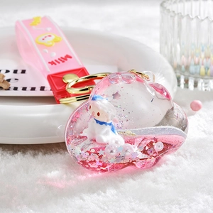 Detail of pink cloud-shaped liquid keychain with glitter, white lamb, and milk strap