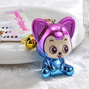 Macro detail of electroplated purple gradient fox keychain with golden bell on plush