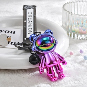 Macro detail of electroplated purple astronaut bear keychain with DREAM ON silicone strap
