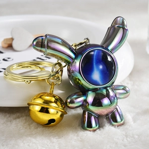 Detail of gradient electroplated astronaut rabbit keychain with gold bell and keyring