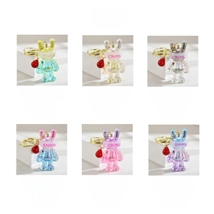 Detailed view of colorful gradient acrylic rabbit keychains with unique wording and red beads