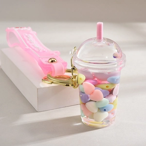 Detail of creative bubble tea cup keychain with pink liquid and heart beads