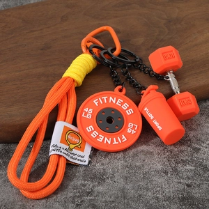 Détail de mini plaques de musculation et pendentif shaker sur porte-clés orange tressé