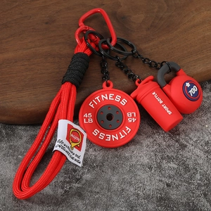 Détail du porte-clés fitness rouge avec mini disque de fonte, shaker et kettlebell