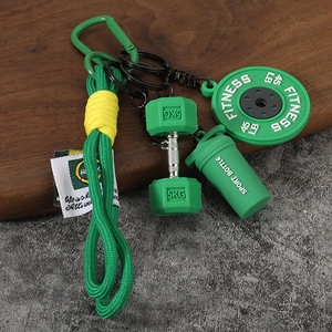 Détail macro du porte-clés fitness avec disque de musculation vert et haltère