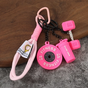 Vue détaillée du porte-clés fitness rose avec disque d'haltère et accessoires de sport