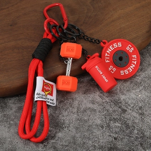 Détail d'un porte-clés fitness avec mini haltère rouge et gourde de sport sur lanière