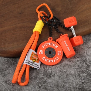 Détails des breloques haltères et shaker sur un porte-clés fitness orange vif tressé