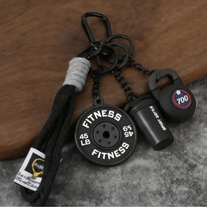Macro d'un porte-clés fitness avec disque d'haltère, shaker et breloque de kettlebell