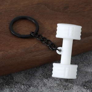 Detailed macro view of white silicone dumbbell keychain with black metal ring and chain