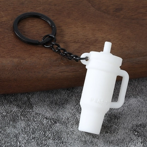 Detailed macro view of white silicone mini cup keychain with black metal ring and PERSIST logo