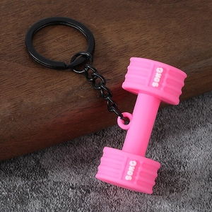Macro shot of a pink mini dumbbell keychain with 50KG engraving and black metal ring