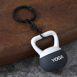 Macro detail of kettlebell keychain with YOGA lettering on a wood and stone texture