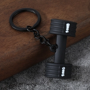 Detailed view of a black 50KG dumbbell keychain with a matte finish and metal ring