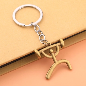 Macro shot of a bronze weightlifting figure pendant on a silver metal keychain